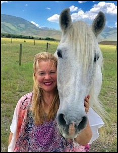 Woman with white horse in field